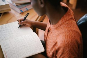 photo-of-woman-writing-on-notebook-3059749